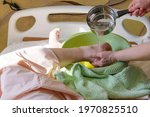 Small photo of Rinsing feet of a bedridden patient. Nurse pours water from a ladle onto the leg. Concept of caring for a bedridden patient with dementia, stroke.