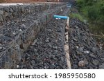 Small photo of Gabion wall constructed using steel wire mesh basket. Stone walls, protection from backshore erosion. Gabion and rock armour - coastal and waterways protection.