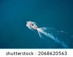 Top view of a white high-speed boat. Yacht movement on blue water top view. Luxury yacht on the water aerial view. White yacht fast movement on the water top view. Travel - image.