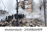 Small photo of Kharkiv, Ukraine - January, 23, 2024: Rubble of a residential building destroyed by a missile strike in a Ukrainian city. A rescue operation is underway. Rescuers are dismantling the ruins. Smoke