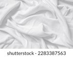 Closeup of rippled white silk fabric,white fabric draped in soft waves empty bed sheet