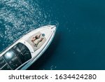 aerial view of couple enjoying sunbathing on the luxury yacht moving in the sea. Travel vacation