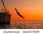 Young Man Jumping Off Yacht...