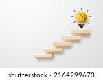 Concept creative idea and innovation. Paper scrap ball yellow colour with light bulb symbol on top step staircase growing growth