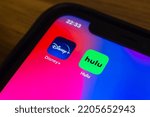 Small photo of Vancouver, CANADA - Sep 23 2022 : Closeup Disney Plus (Disney+) and Hulu icons on an iPhone screen. Big subscription streaming services merger concept