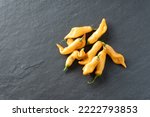 Heirloom bright gold sugar rush peach peppers on a gray slate background; food