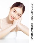 Small photo of Asian woman with a beautiful face gathered in a brown ponytail and clean fresh smooth skin. Cute female model with natural makeup and look at camera on white isolated background.
