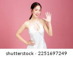 Small photo of Young Asian woman gathered in ponytail with natural makeup on face have plump lips and clean fresh skin wearing white camisole open mouths raising hands announcement on isolated pink background.