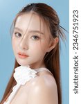 Small photo of Young Asian beauty woman model long hair with natural makeup look on face and perfect clean skin on isolated blue background. Facial treatment, Cosmetology, Spa, Aesthetic, plastic surgery.