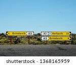 Yellow plaques with direction and distance to Grindavik and the Keflavik airport in a road in Iceland.