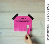 Small photo of Happy World Compliment Day. Take a compliment. Pink wall paper sticker with text of popular compliments for beautiful lady pasted on wooden background. Creative concept.