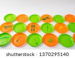 Small photo of Disposable plates. Colorful bright plastic plates setting apart and having forks and skewers as example of unsystematic consumption