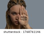 Stop racism. Young African American woman covering half of her face with palm with stop racism lettering