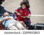 EMT strapping the patient to the stretcher