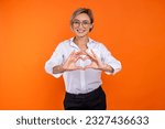 Romantic woman wearing white official style shirt showing heart shape with hands