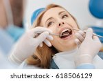 Small photo of Scrupulous competent dentist cleaning patients teeth