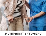Small photo of Admirable caring nurse helping feeble lady