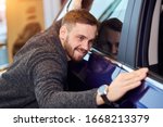 Small photo of smiling man adores his new modern luxury car. love at first sight, guy checking the polish of the car after mending it. close up photo. you are my baby