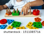 
Children's wooden toy. The child collects a sorter. Educational logic toys for kid's. Children's hands close-up. 
Montessori Games for Child Development