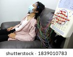 Small photo of Latin woman with protection mask in medical tests, electroencephalogram and brain mapping in times of covid-19 contingency