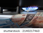 Russian currency on the background of the dollar and burning gas.The concept of gas and oil payment in Russian currency.Selective focus.