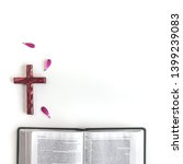 Small photo of Flat lay open Bible or book and pink/purple/violette/red Gerbera flower on a white background. With pink petals and wooden cross. Baselland, Switzerland - 03.05.2019.