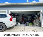 Small photo of Orlando, FL USA - July 10, 2021: An unorganized garage filled with a lot of stuff in a neighborhood.