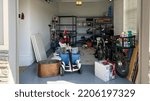 Small photo of Orlando, FL USA - March 3, 2022: An unorganized garage filled with a lot of stuff in a neighborhood.