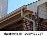 Small photo of Roof gutters with a downspout on a residential house