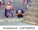 Tourist refreshes his head with ...