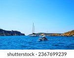Small photo of ISOLE TREMITI, ITALY - AUGUST 9, 2016: View from Tremiti Islands. A couple of boats skimming the wavy blue surface of the Adriatic Sea, with a vision of rocky spurs and musky green vegetation
