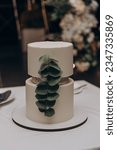 Small photo of White three tier wedding cake. Vanilla biscuit cake, cream cheese cream. The cake is decorated with pink and red roses and green leaves. Wedding cake.