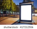 Mock up of blank white vertical light box on a bus stop in a city at night