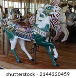 Small photo of Green and white carousel horse bedecked with saddle and tassels