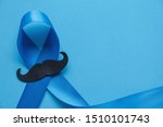Small photo of Light blue ribbon with mustache on blue background , Prostate Cancer Awareness, Movember Men health awareness, November Blue, International Men's Day