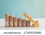 Wooden blocks with percentage sign and down arrow, investment reduce, financial recession crisis, interest rate decline, risk management concept