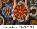 Small photo of Many kinds of food at the hands of family members. Local food named izmir kofte . Iftar concept. Variation of local homemade foods.