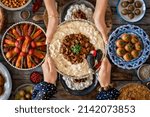Small photo of Many kinds of food at the hands of family members. Local food named hunkar begendi . Iftar concept. Variation of local homemade foods.