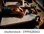 A leather craftsman works in a workshop