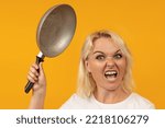 Small photo of an angry woman with an animal grin brandishes a frying pan. last straw concept