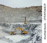 Extraction of slate in the winter in a quarry, drilling of wells before blasting and loading of a dump truck with the extracted rock.