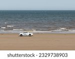 Small photo of North East England, United Kingdom - July 7th 2023 - RNLI pick up truck patrolling the beachon a blustery but sun shining day