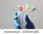 Different sizes of an oropharyngeal airway cannula in a healthcare professional wearing gloves. 