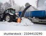 Removing snowdrift from city streets with snow blower.
