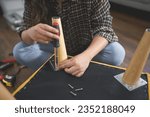 Women use screwdriver equipment to tighten screw while repairing leg of chair and making furniture.