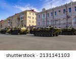 Russian military vehicles on the city street against the backdrop of residential buildings. Russian modern military tank, infantry fighting vehicle BMP and armored personnel carrier BTR.