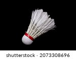 Used shuttlecock that has been broken on a black background