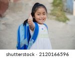 Small photo of Hispanic girl ready to go to school in rural area - Latin girl on her way to school - Happy Mayan girl with thumbs up