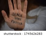 Black Lives Matter written on long haired white woman's hand. Caucasian girl  against racism and police brutality. Support to African Americans.