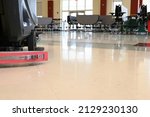 Small photo of Auto scrubber on a floor in a school cafeteria. Automated floor cleaning machine in public space. Janitorial maintenance